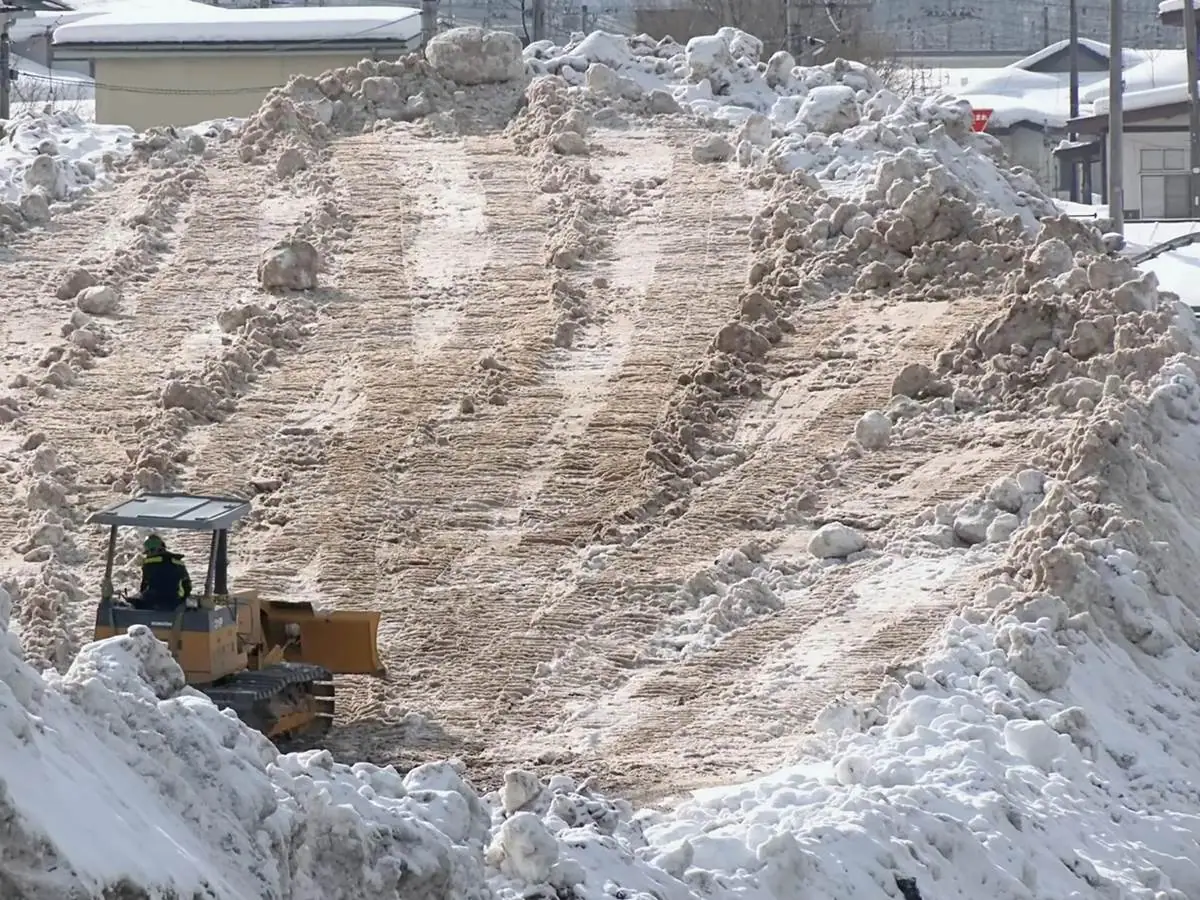 雪捨て場で稼働中のブルドーザー = 2022年1月29日 東町