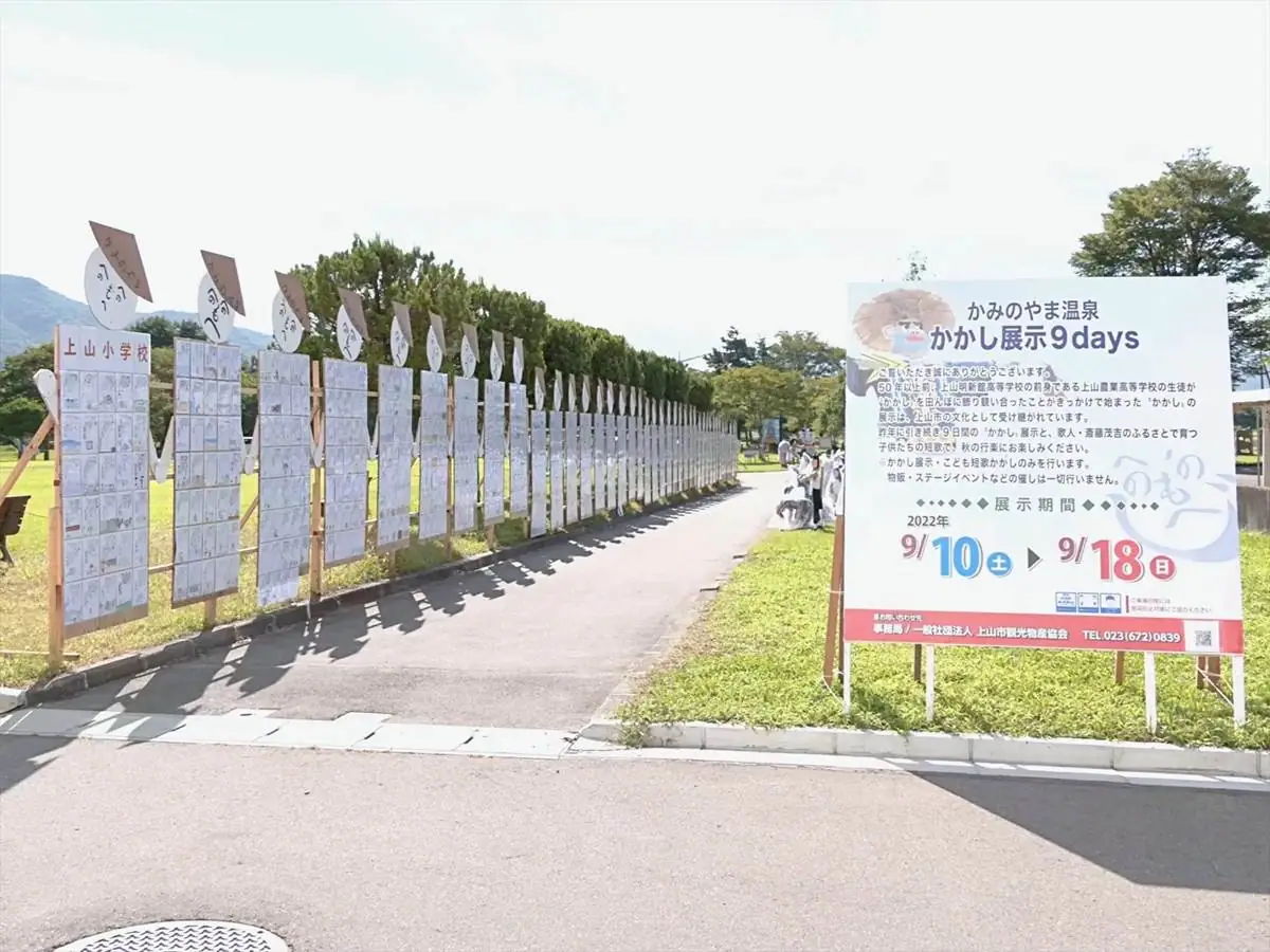 イベントの案内板と写真左側に子供たちの短歌 = 2022年9月11日 市民公園