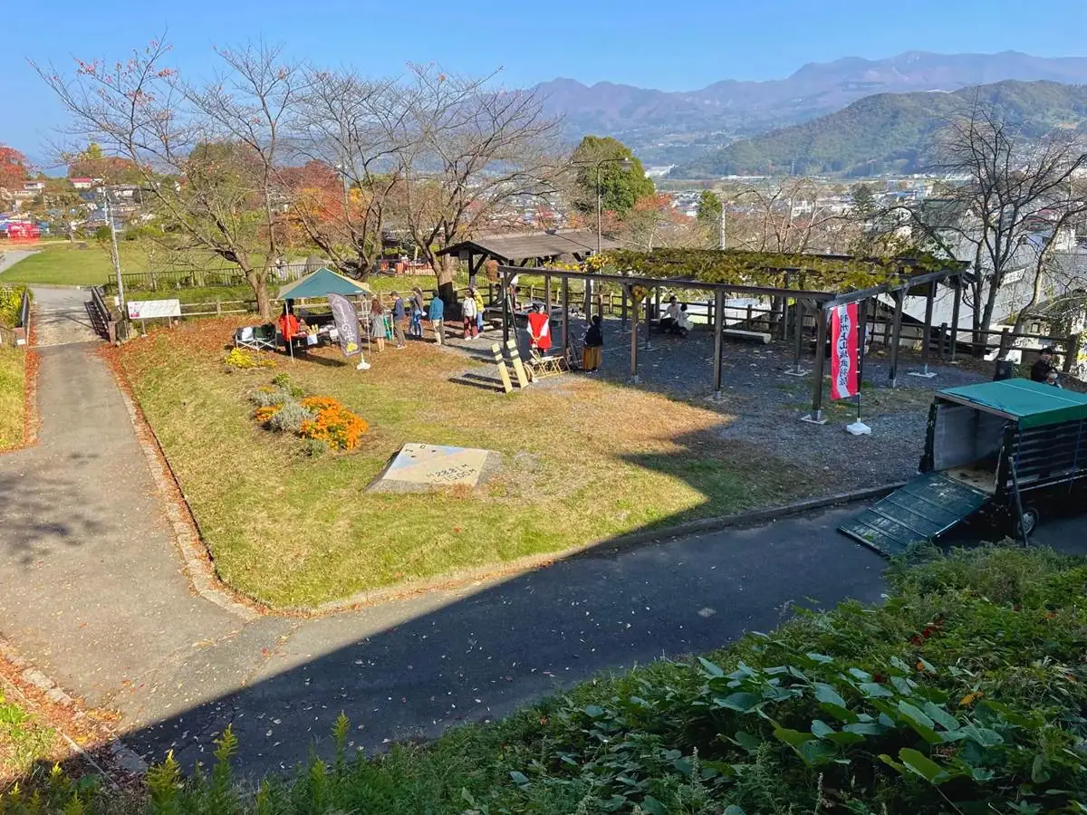 写真中央には上山城の足湯、その左側にミニ動物園 = 2023年11月3日 上山城前