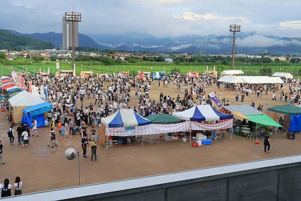 会場に集まる見物客と出店者ら = 2024年7月27日 三友エンジニア体育文化センター