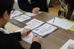 ワイワイ話しながら謎解きする参加者ら(1) = 2025年3月9日 アビヤント・K