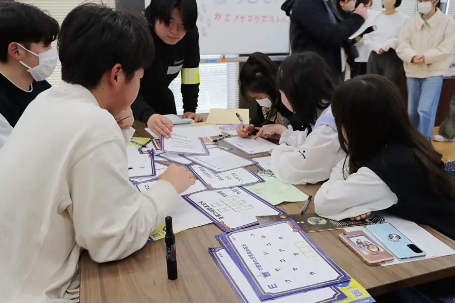 ワイワイ話しながら謎解きする参加者ら(5) = 2025年3月9日 アビヤント・K