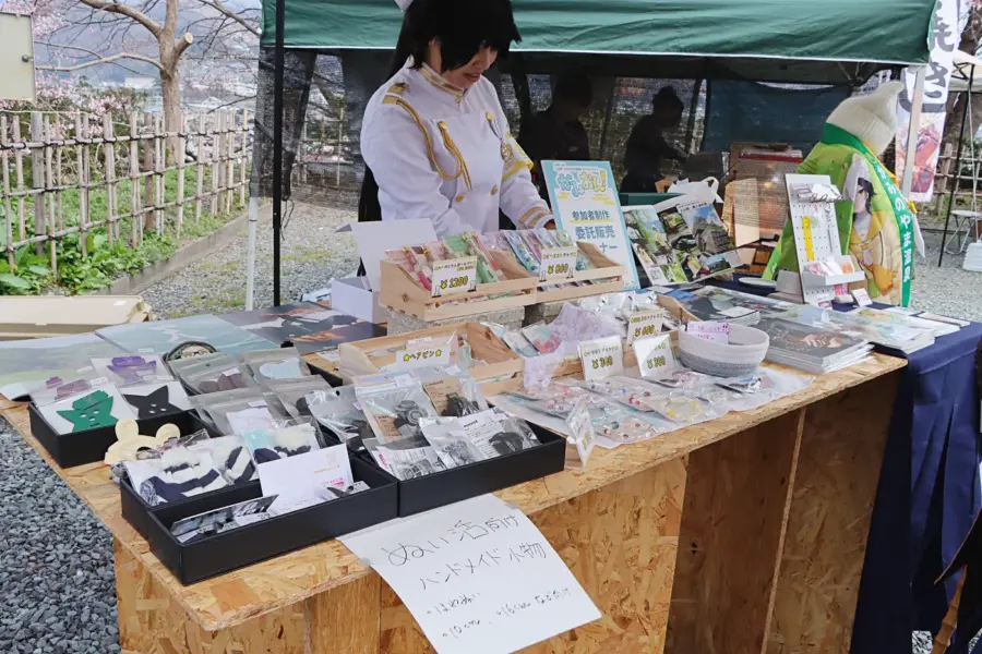 コスプレイベント主催者のBrownさんも自身が出版するガイドブックなどを販売した = 2025年4月12日 上山城前