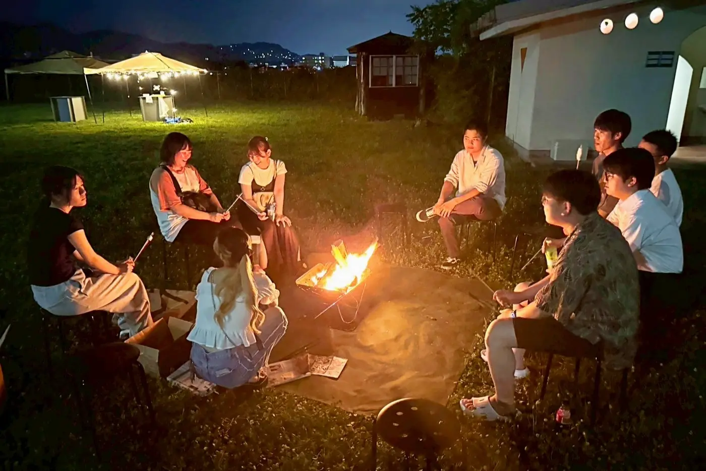 焚き火を囲んで交流する若者たち(イベント1回目の様子) = 2025年7月19日 長清水公園