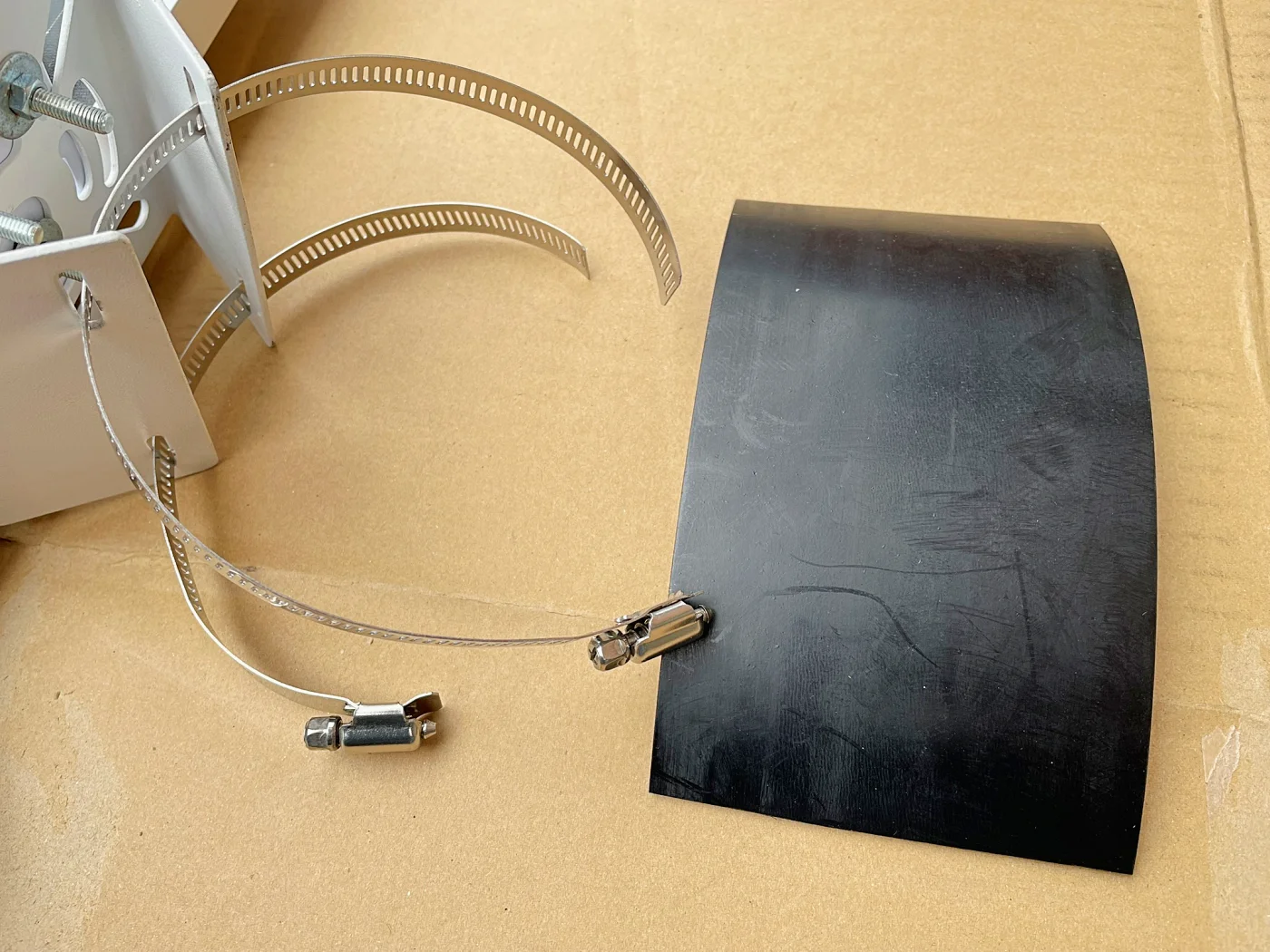 ゴム板をバンドと雨どいの間に設けて固定します