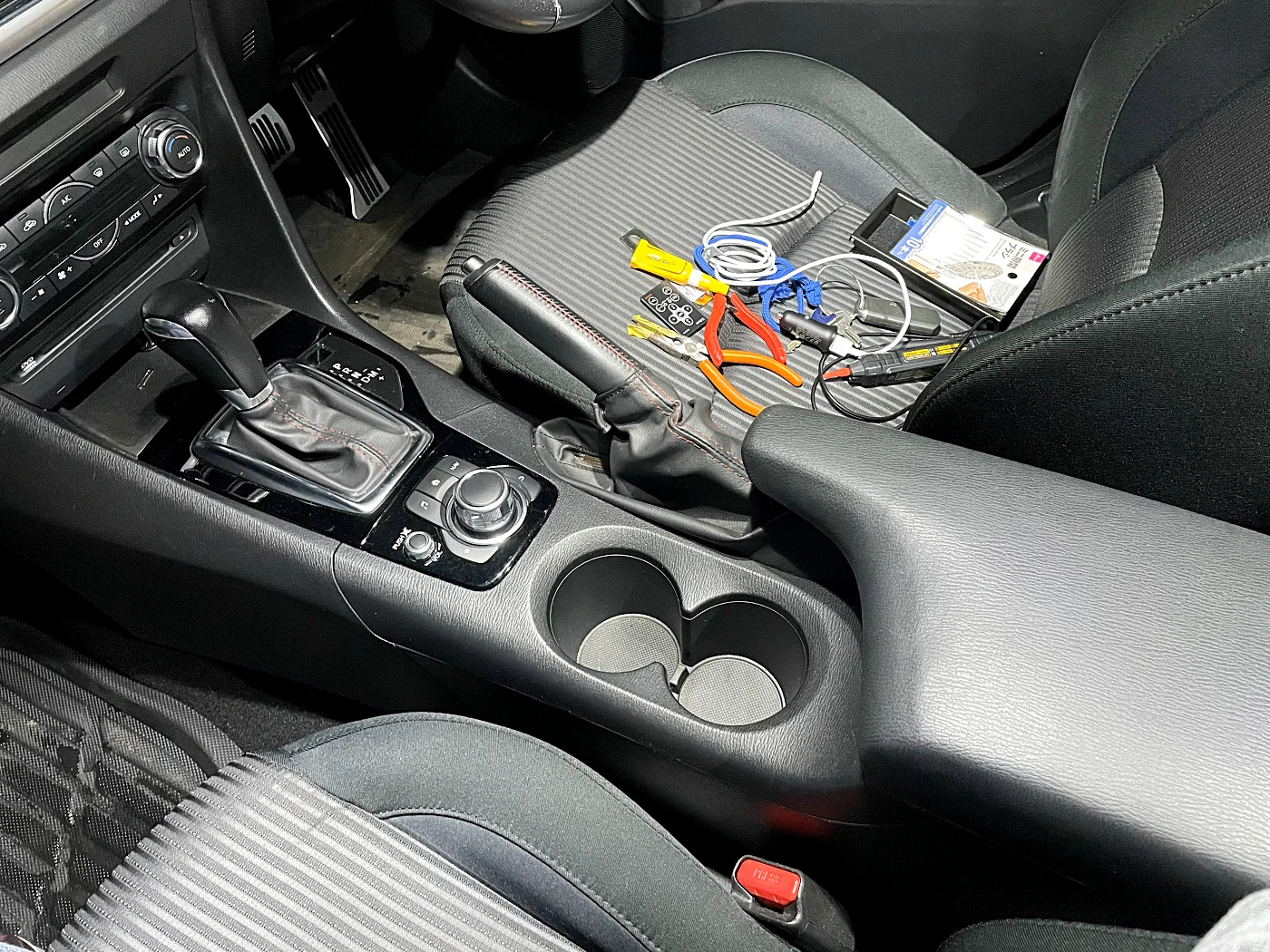 ドリンクホルダーのパネル、シフトノブのパネル、小物置きを外します