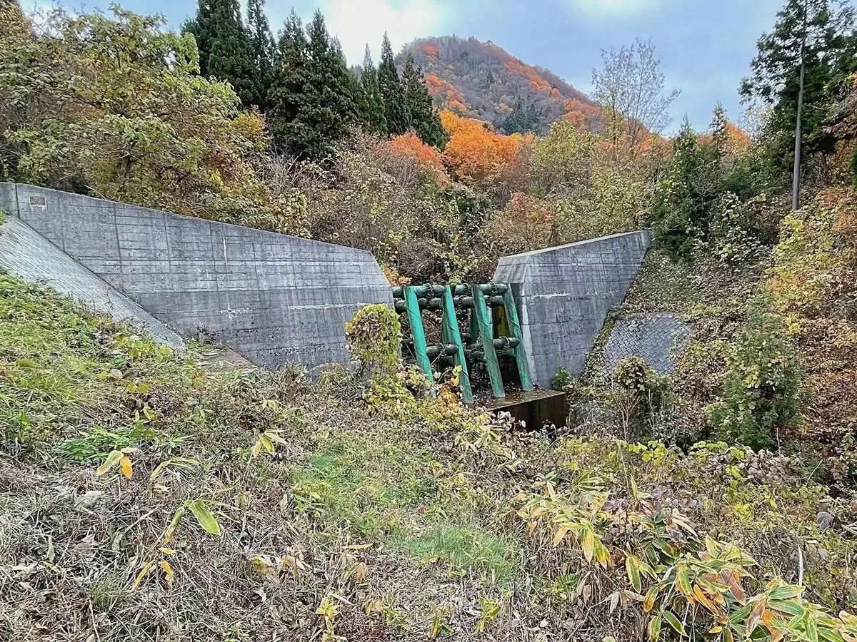 奥に見える三吉山の麓にある砂防ダム。この場所の地下には東北中央道の三吉山トンネルが通っている。